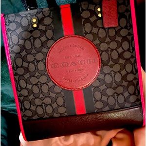 The bag is coach pink, brown logo, and signature black and gray coach colors.